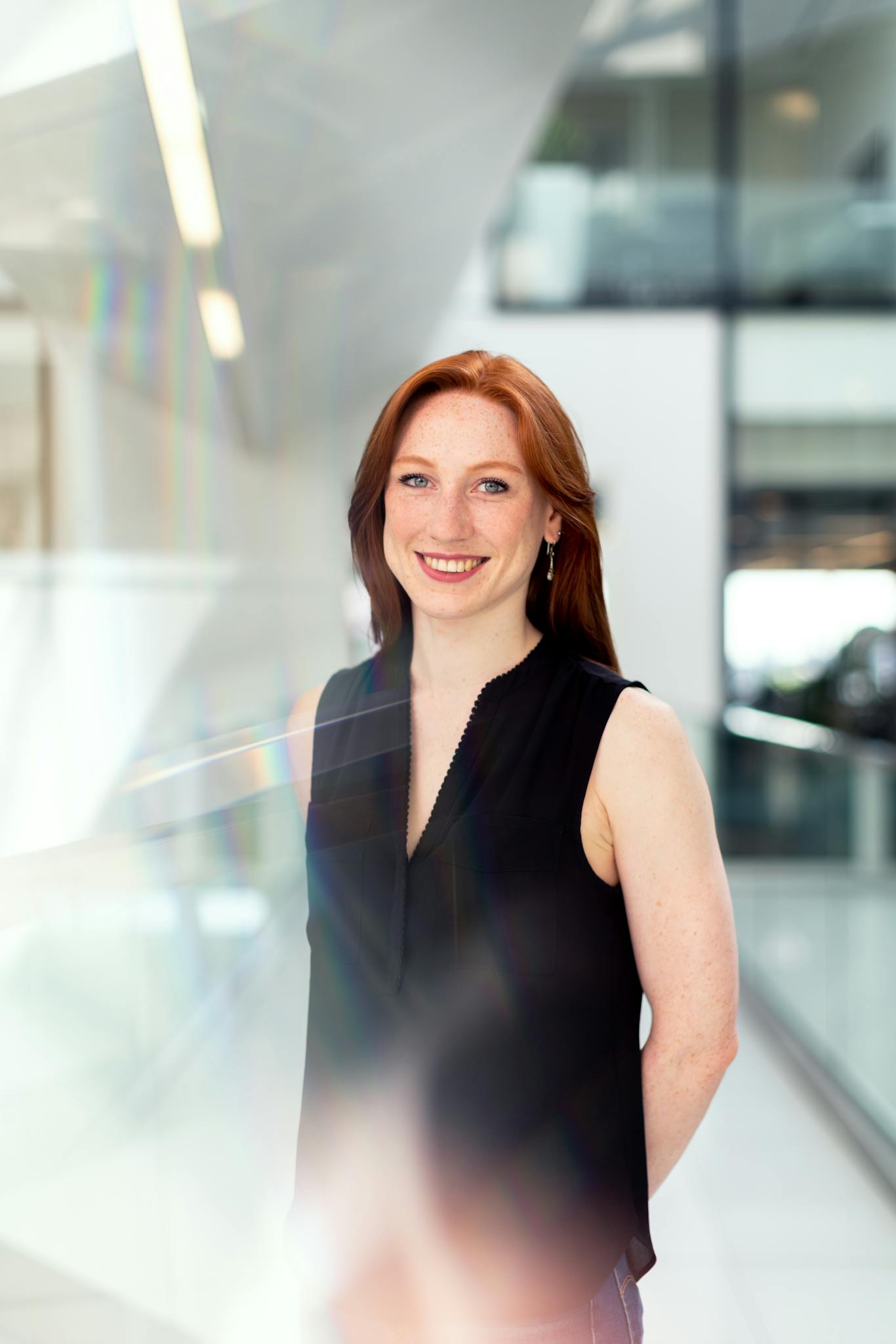 Confident businesswoman smiling in a bright modern office setting.
